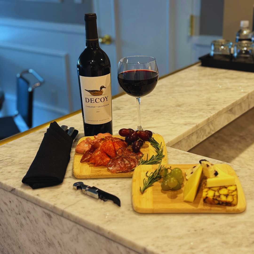 a bottle of wine and a plate of food on a counter