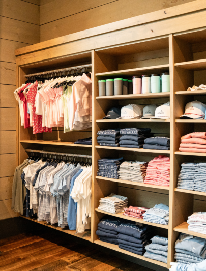 a closet with clothes on swingers and a rack of clothes