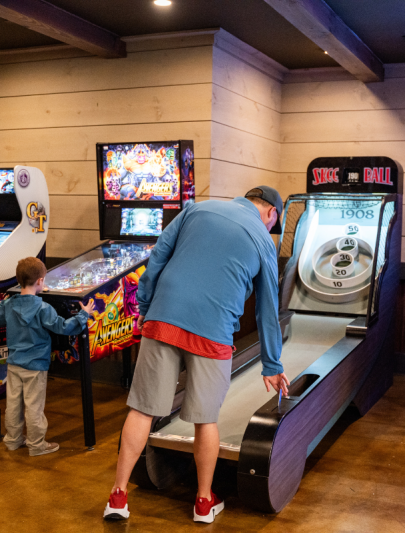 a man and boy playing pinball