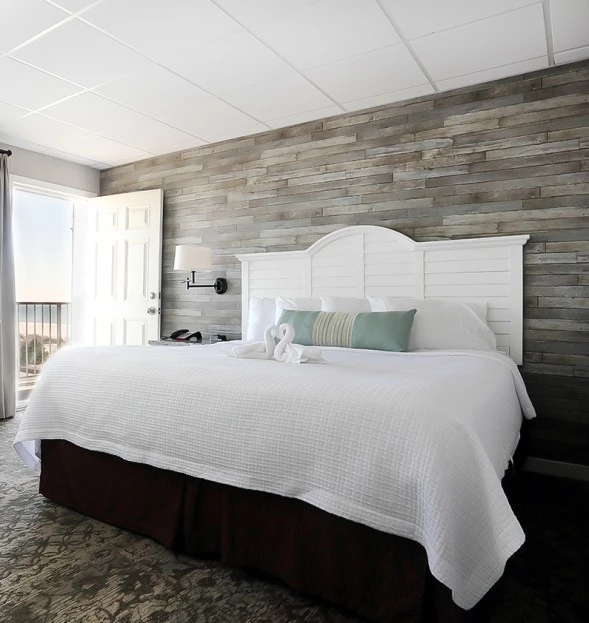 a bed with a white headboard and a wood wall