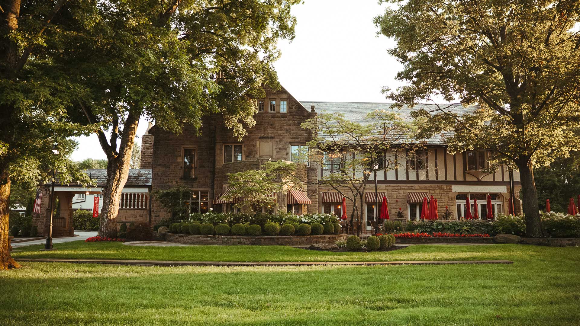a large brick building with a lawn and trees
