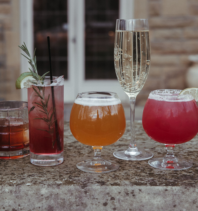 a group of glasses of different colored drinks