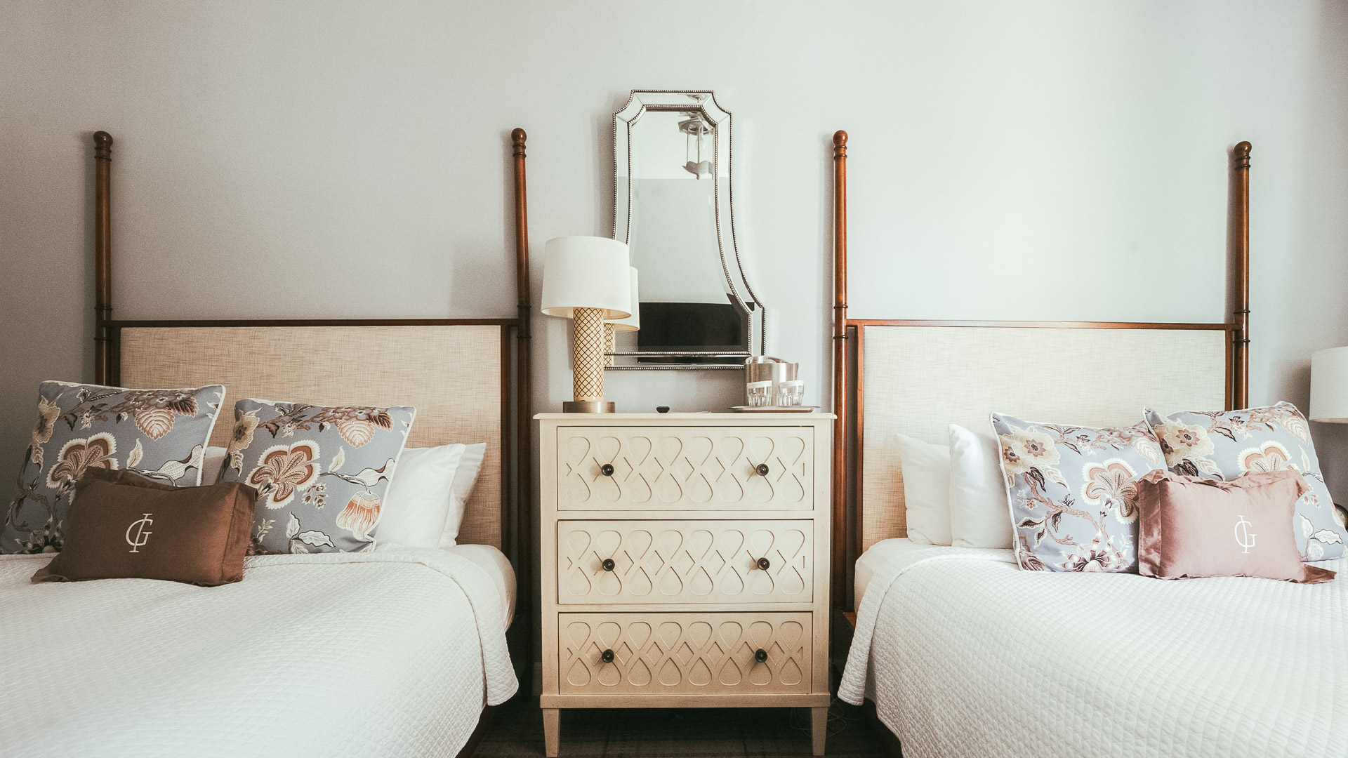 a bedroom with two beds and a mirror