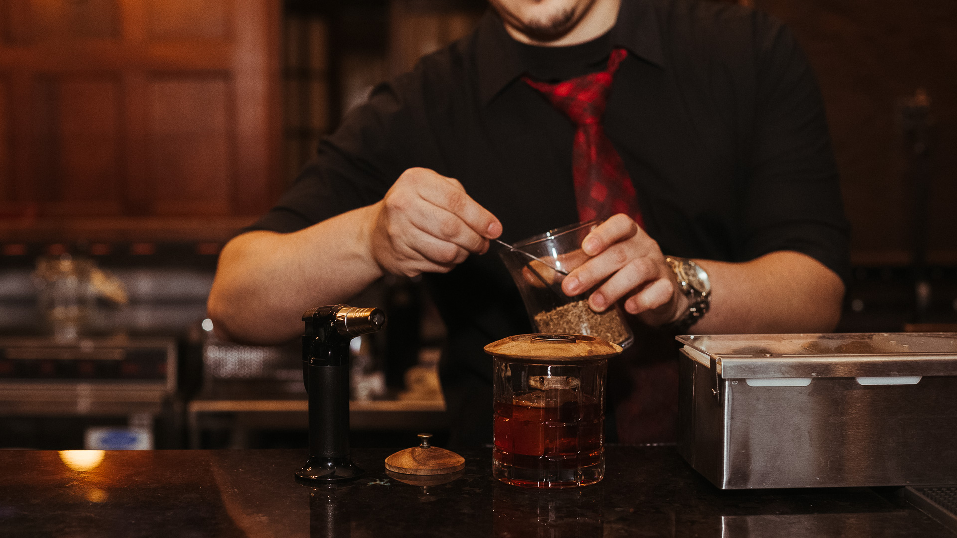 a man pouring a drink into a glass