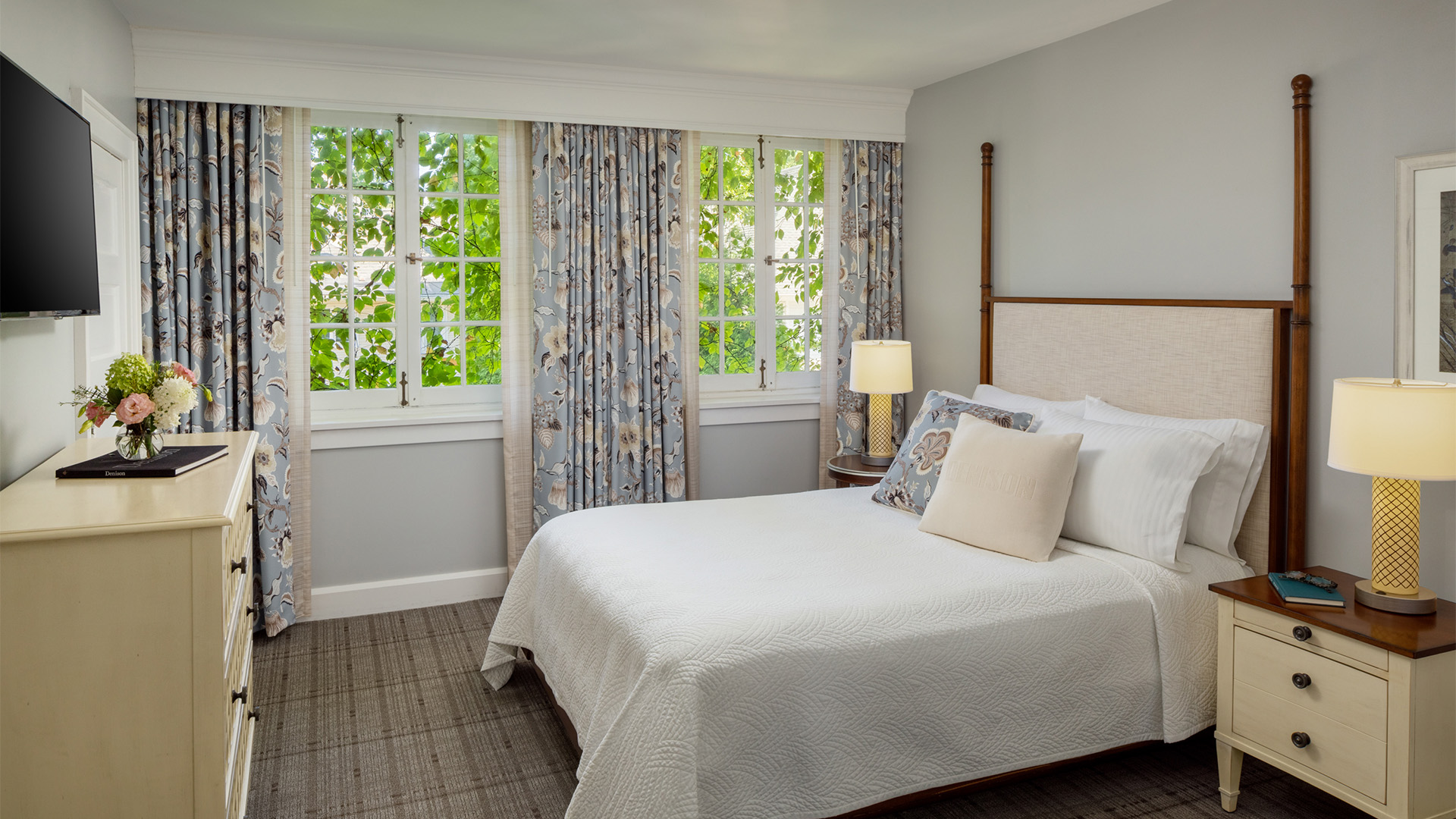 a bed with a lamp and windows