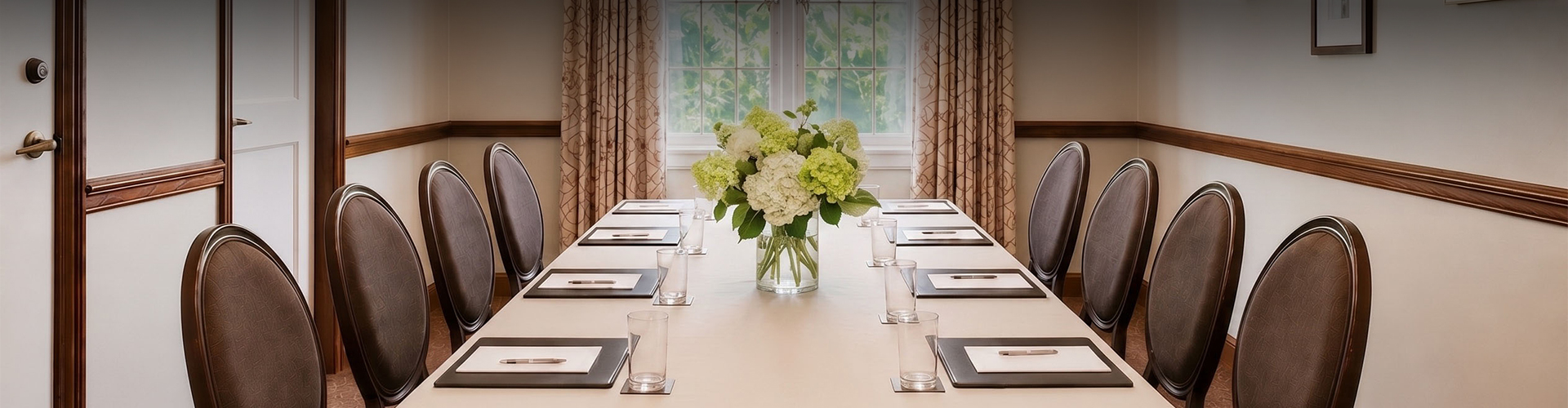 a table with a vase of flowers and glasses on it