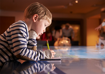 a young boy writing on a book