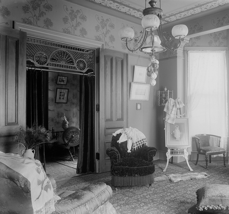 a living room with a chandelier and chairs