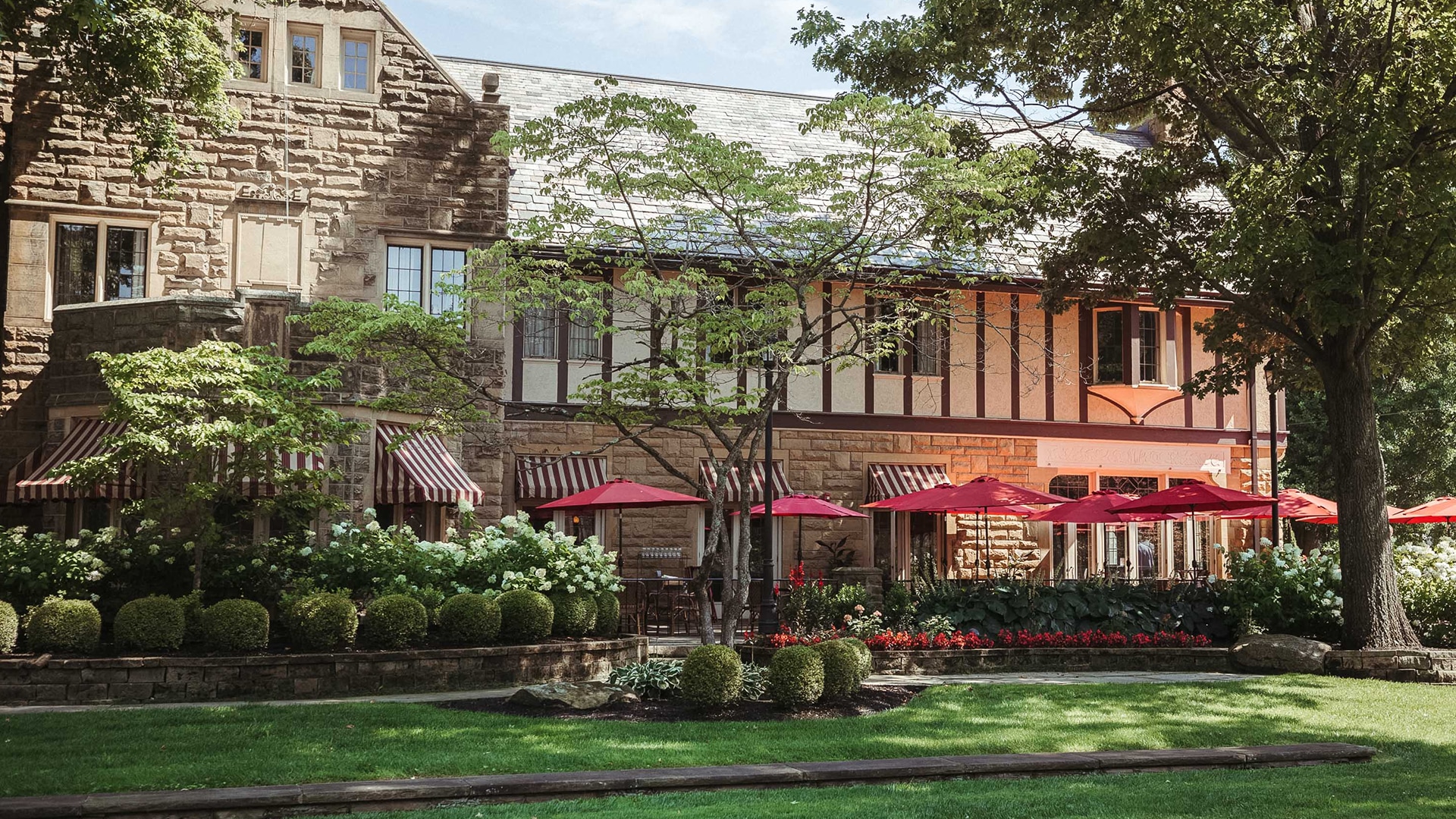 a building with red umbrellas and flowers
