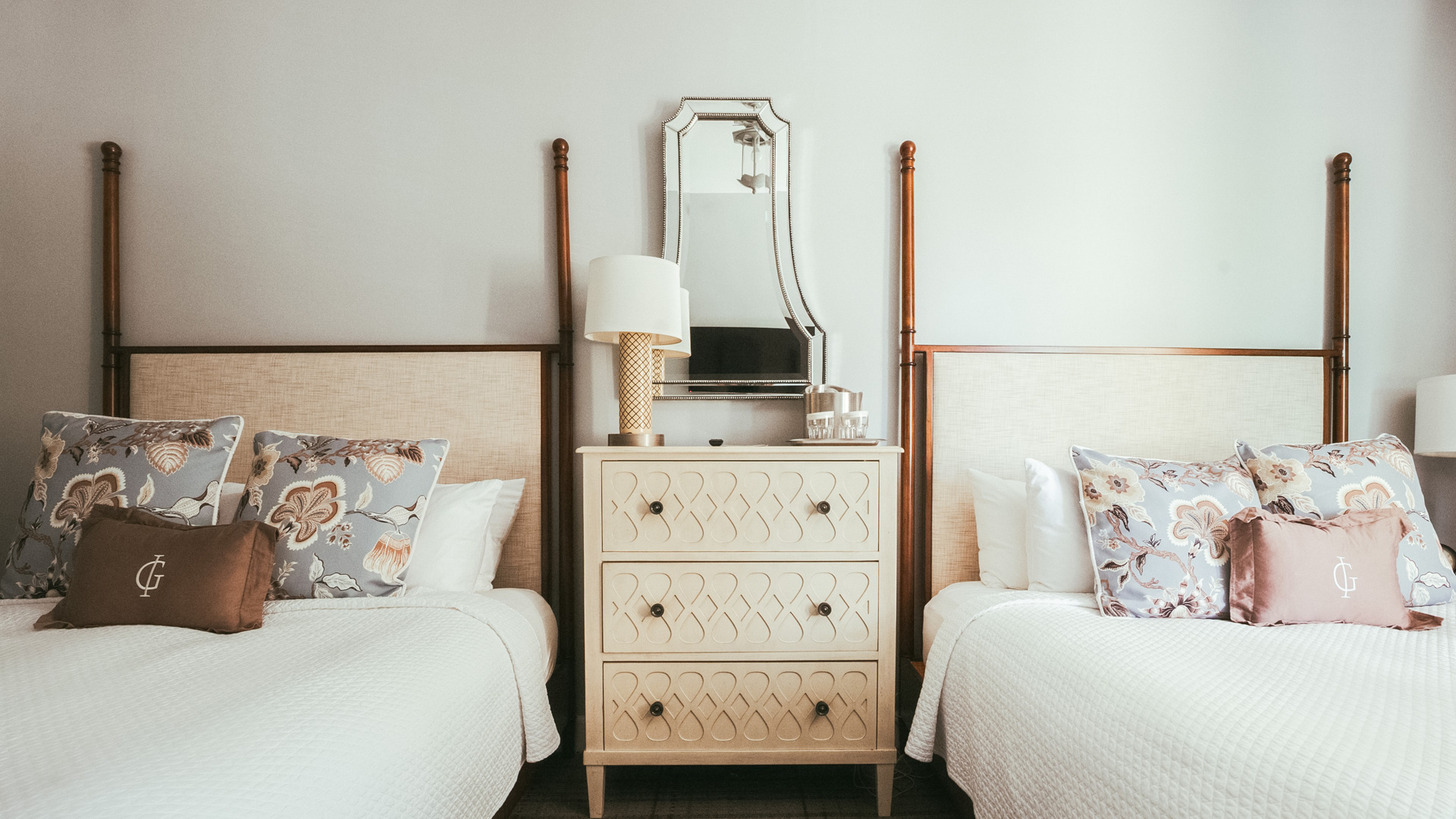 a bedroom with two beds and a mirror
