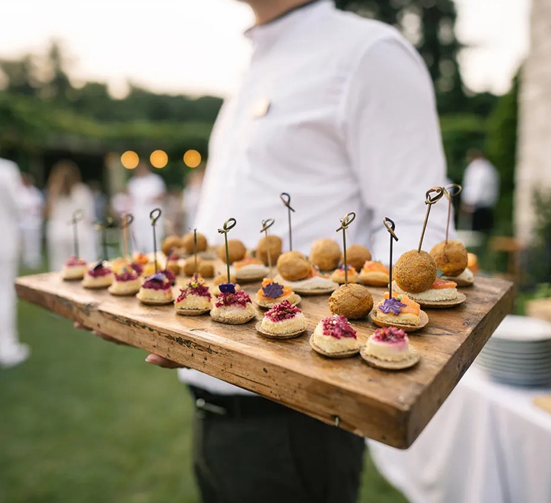 a person holding a wooden tray of food