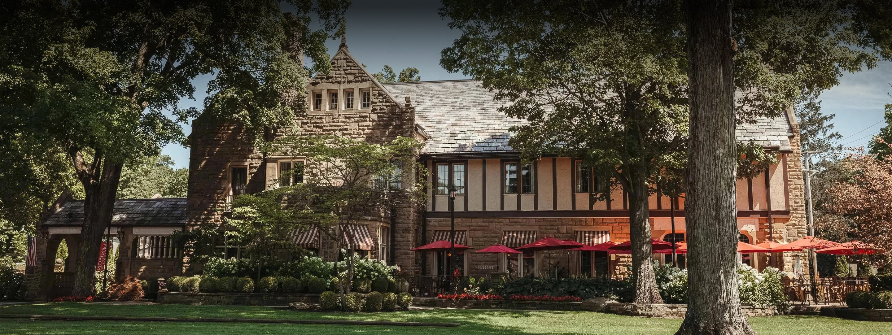 a building with red umbrellas and trees