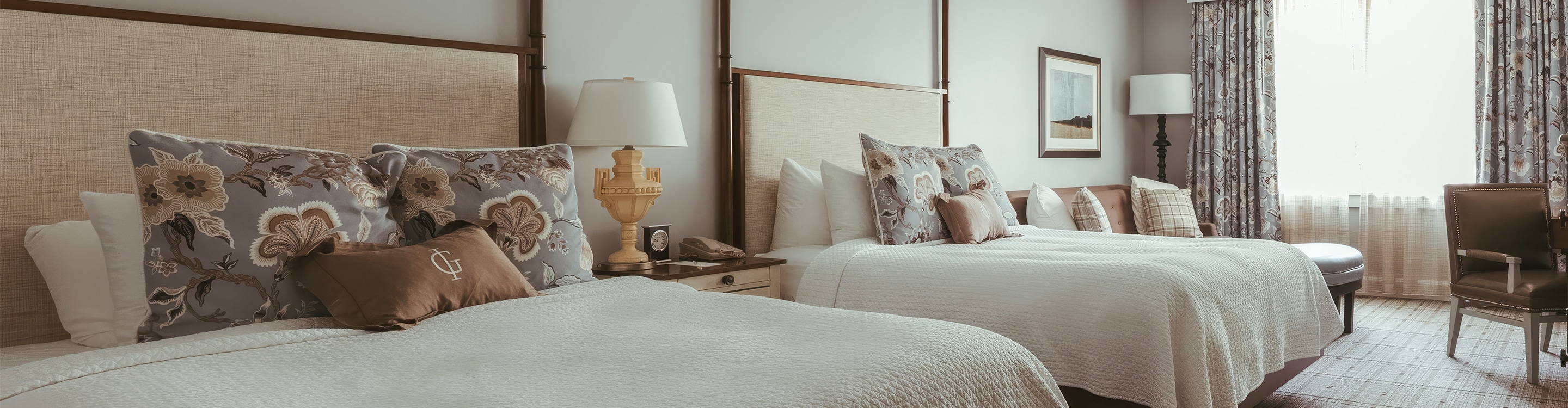 a bed with pillows and a lamp on a nightstand