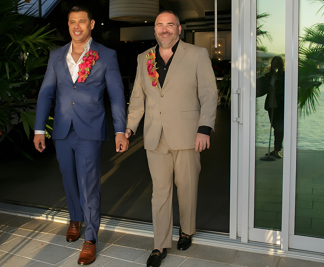 two men in suits walking by a glass door