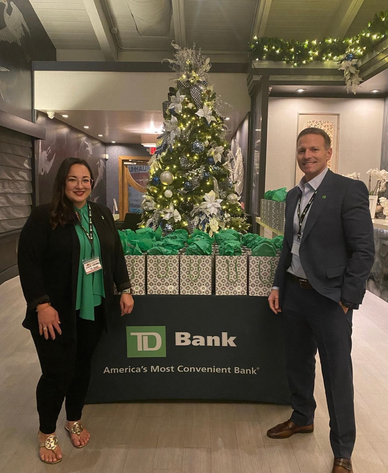 a man and a woman standing next to a christmas tree