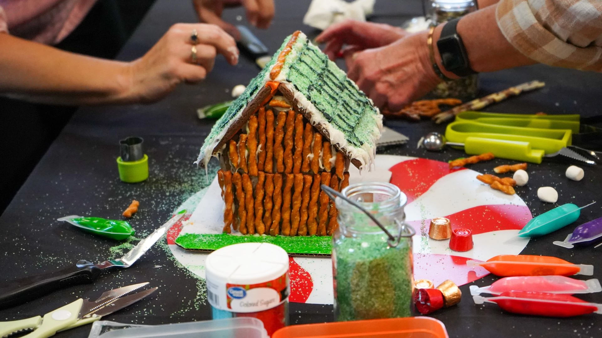 a gingerbread house with pretzels and sugar sprinkles