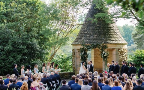 a group of people sitting in chairs in front of a wedding ceremony