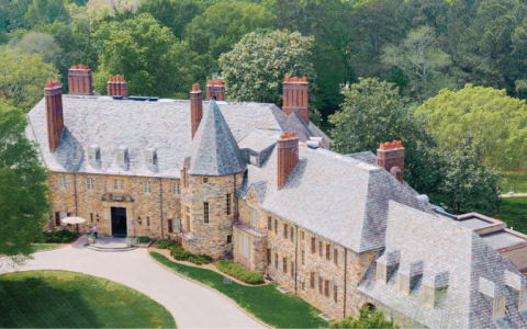 a large stone house with trees in the background