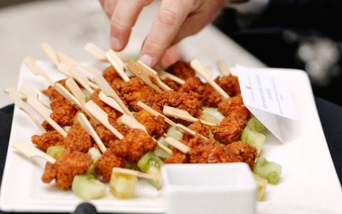 a plate of food with a finger pointing at a plate of food