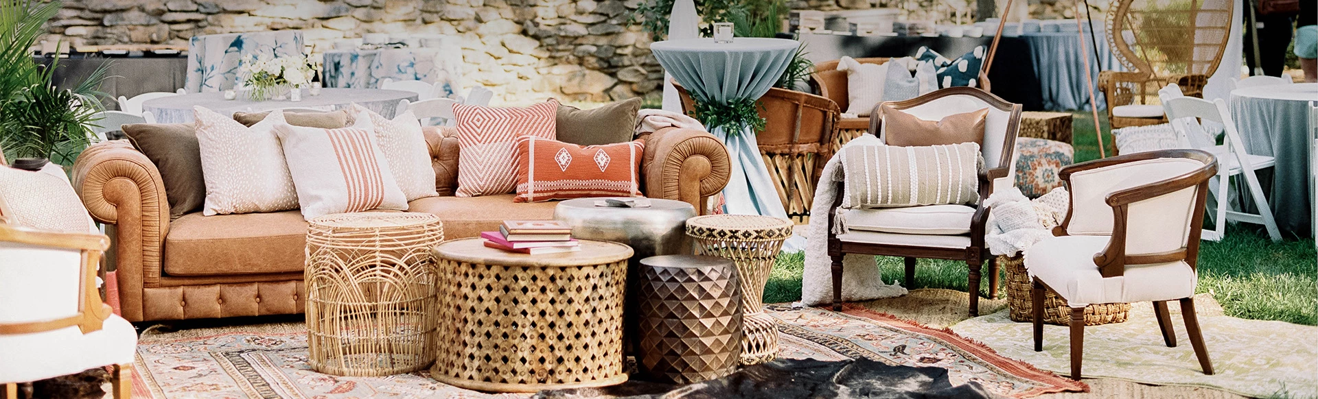 view of a sofa with pillows and different tables and arm chairs 