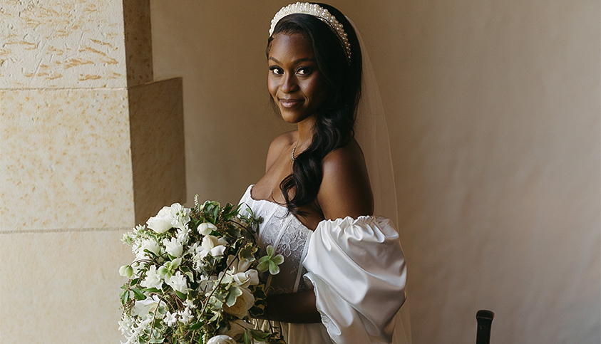 a woman in a white dress holding a bouquet of flowers