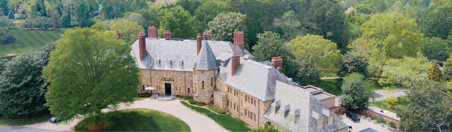 a large stone house with trees in the background