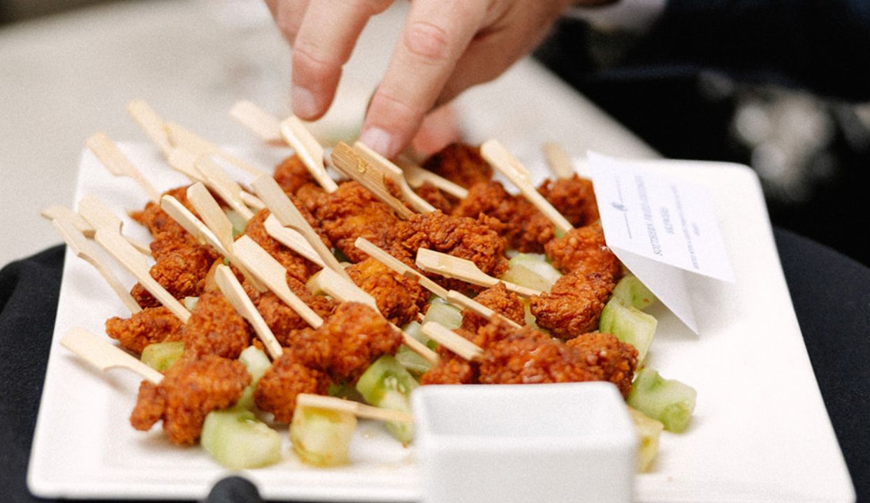 a plate of food with a finger pointing at a plate of food
