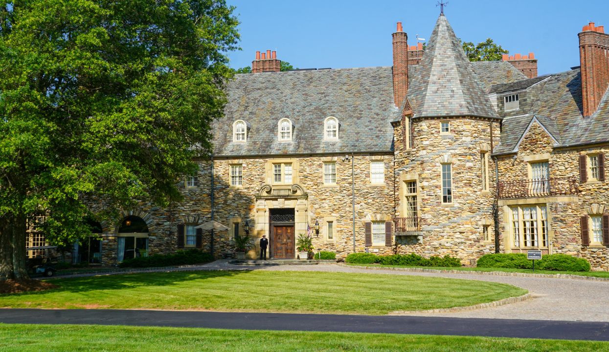 a large stone building with a door and a lawn