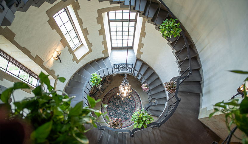 a chandelier hanging from the ceiling and a spiral staircase