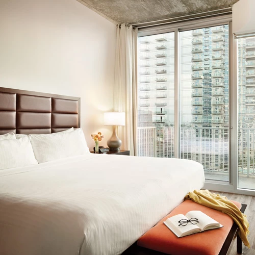 clean king bedroom with balcony viewing the city