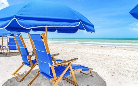 a blue beach chairs and umbrella on a beach