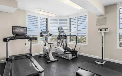 a room with exercise equipment and windows