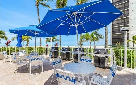 a patio with a table and chairs and umbrellas