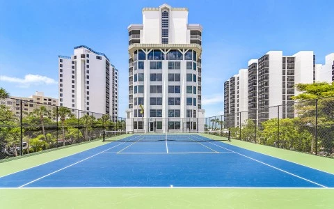 a tennis court in front of a tall building
