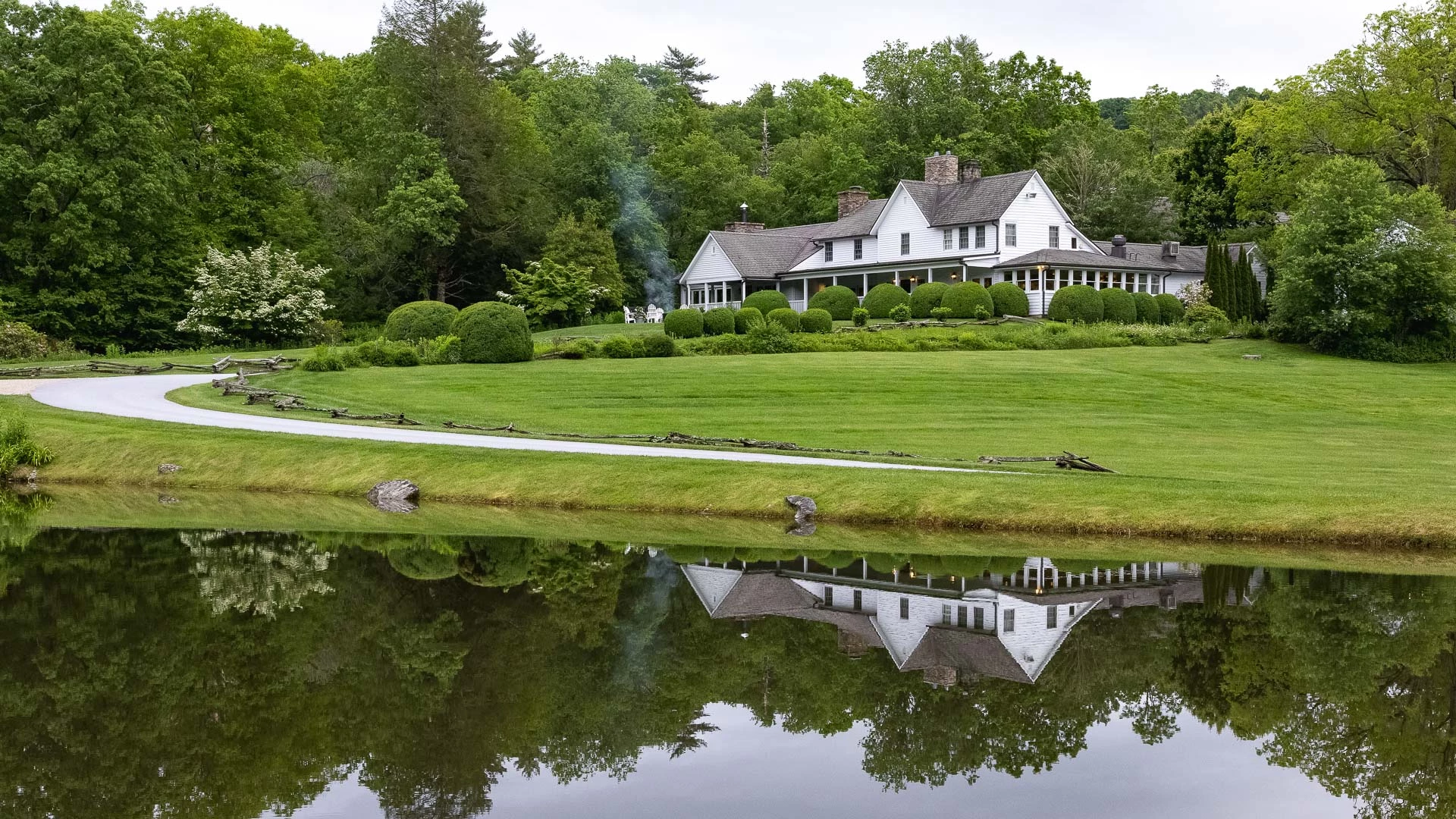 a house with a pond and trees