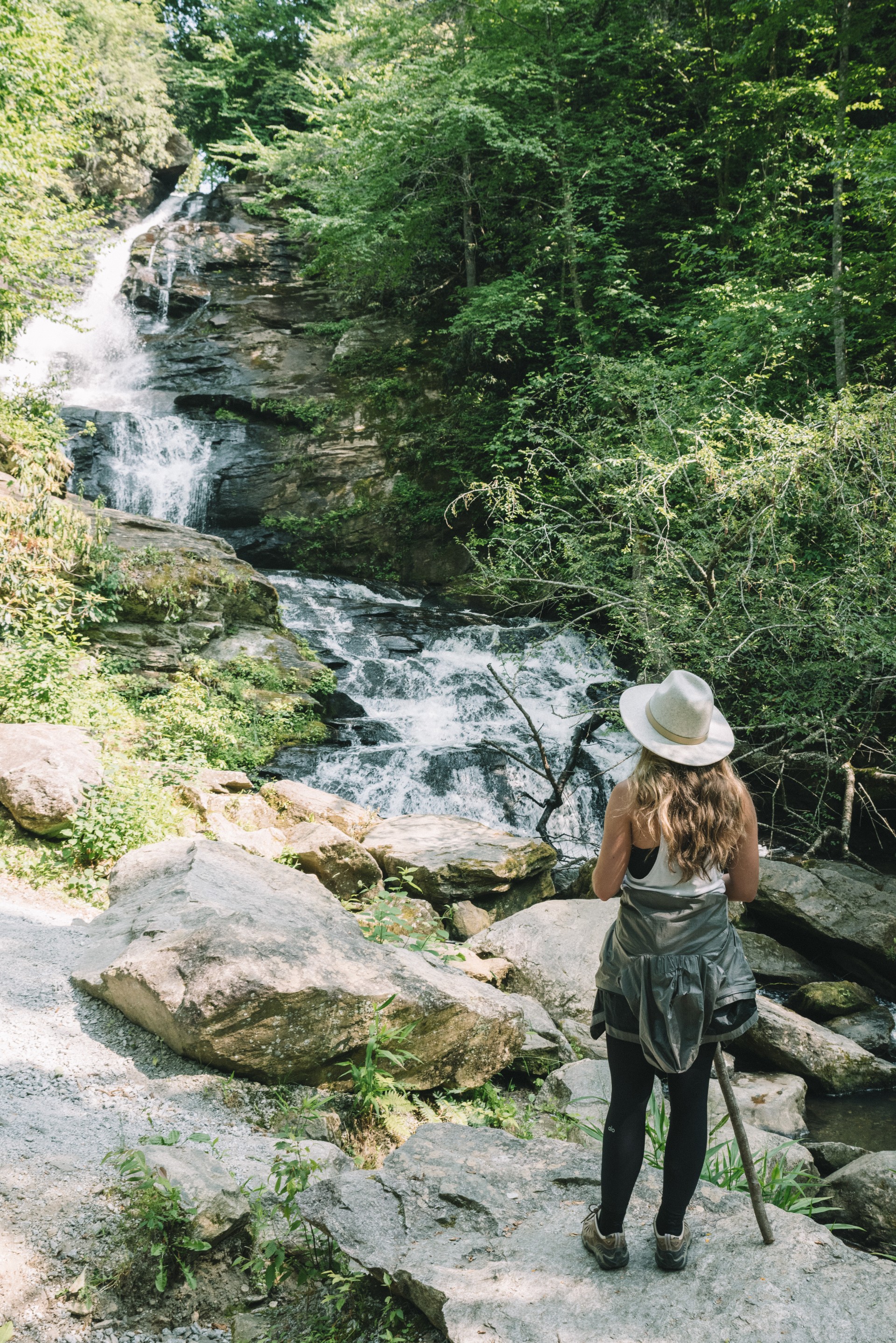 a woman standing near a waterfall