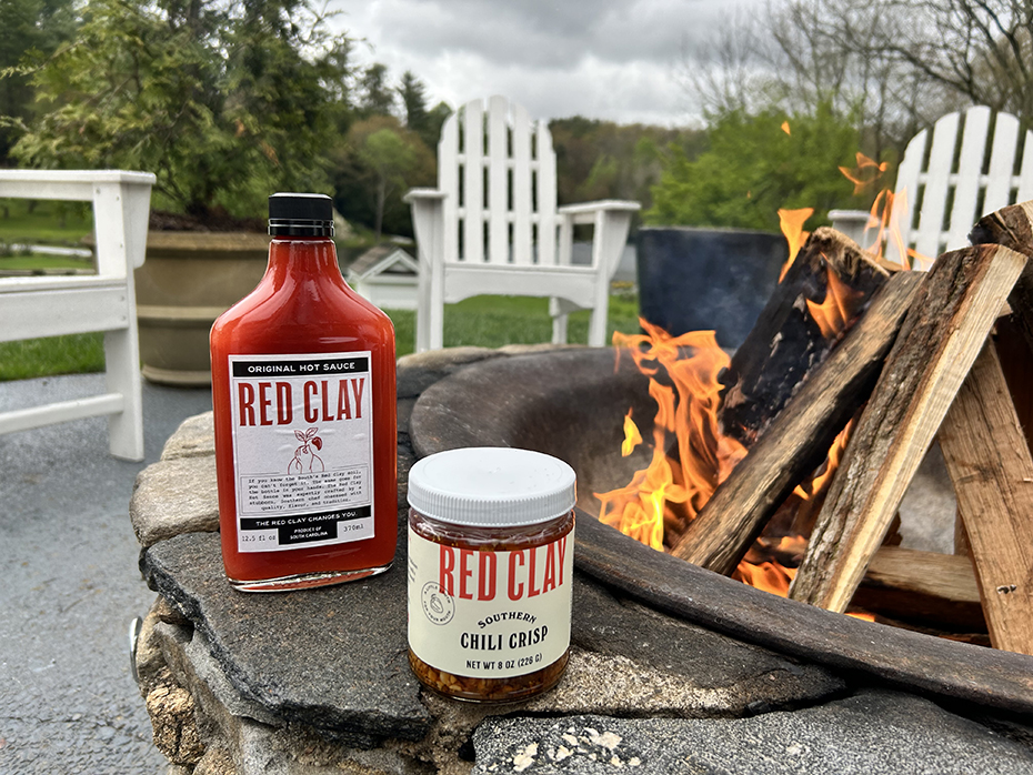 a jar of hot sauce next to a fire pit