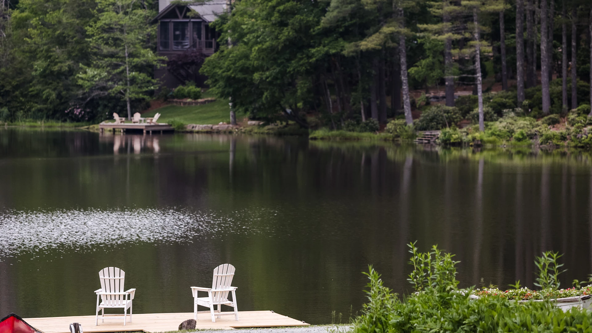 a dock with chairs on it by a lake
