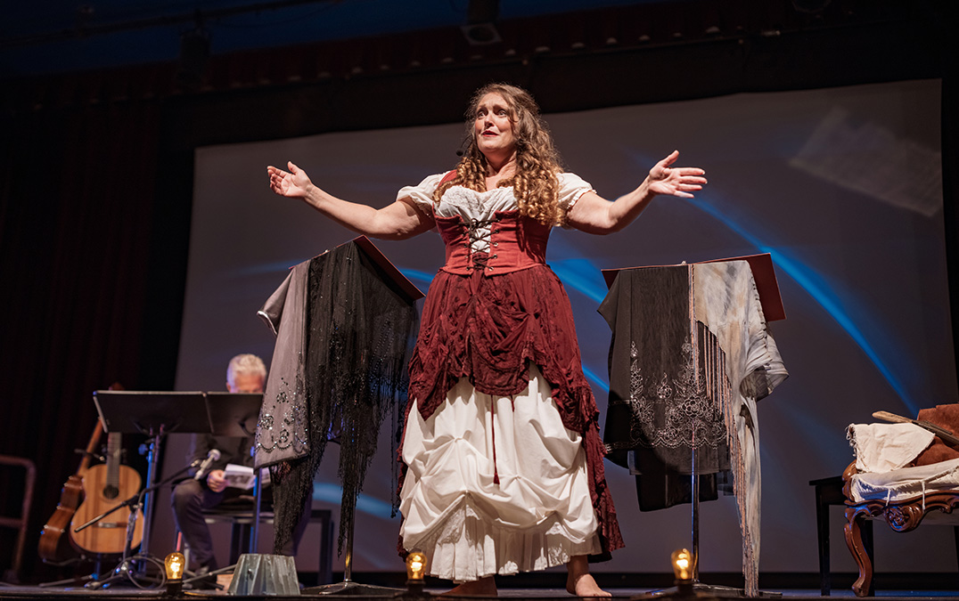 a woman in a dress on a stage with clothes on them