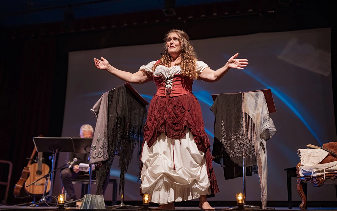 a woman in a dress on a stage with clothes on them
