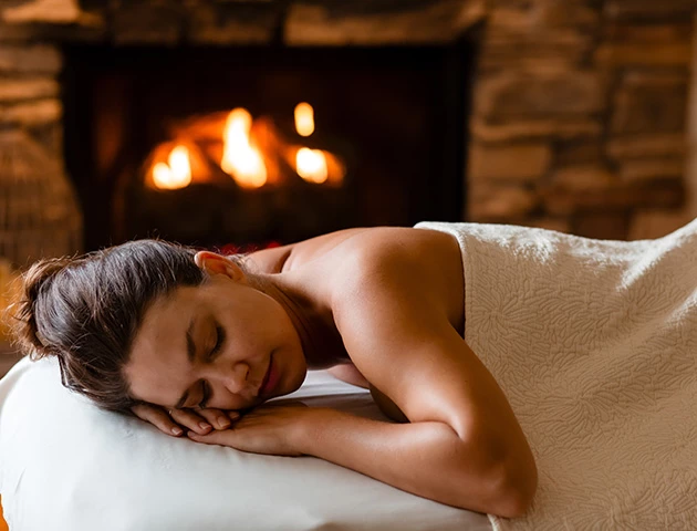 a woman lying on a bed with her eyes closed