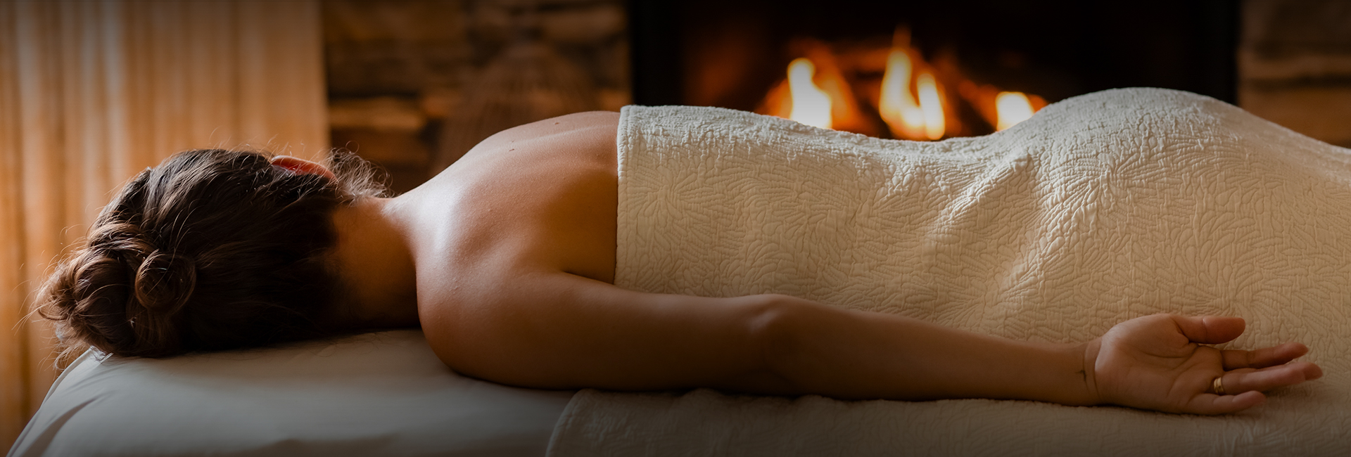 a person lying on a bed with a towel around their back