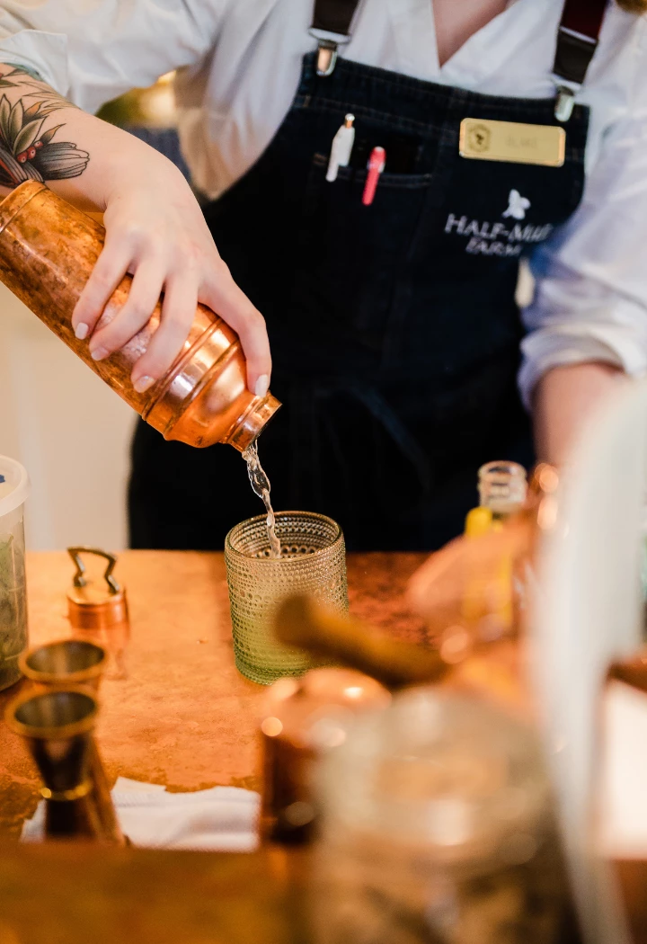 a person pouring liquid into a glass