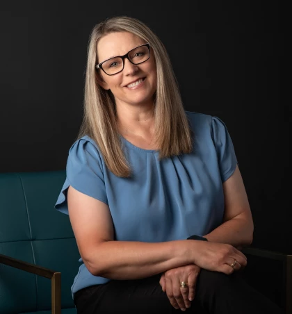 a woman sitting in a chair with a blue blouse