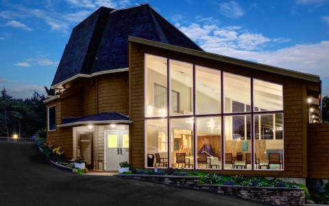 a building with a glass wall and a driveway