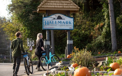 a couple of people riding bicycles in front of a sign