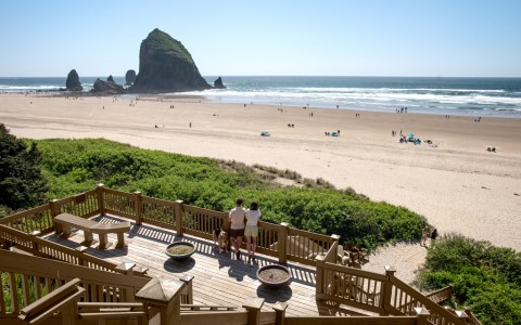a group of people standing on a deck overlooking a beach
