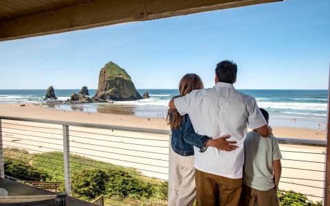 a group of people standing on a deck overlooking a beach
