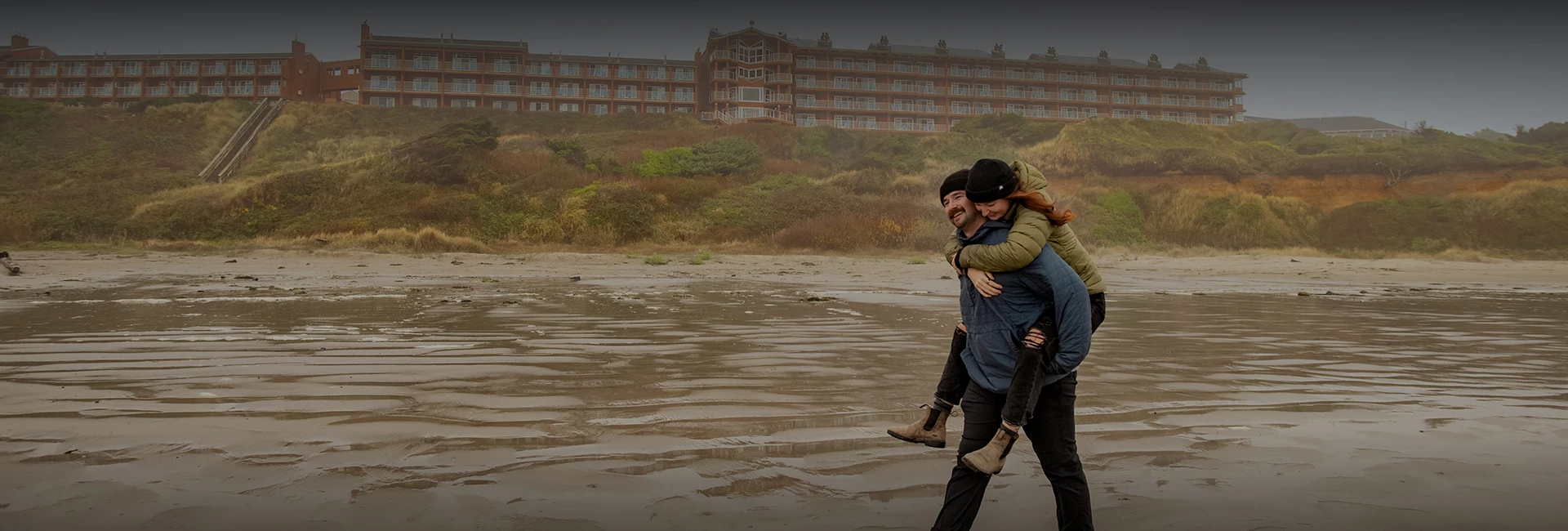 a man carrying a woman on his back on a beach