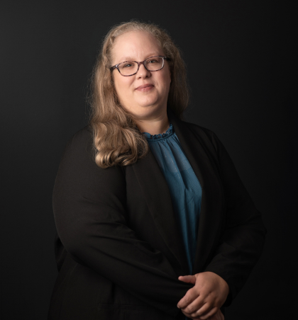a woman in a black blazer and blue blouse